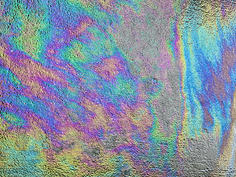 Iridescent colors oil gasoline spill abstract background pattern.