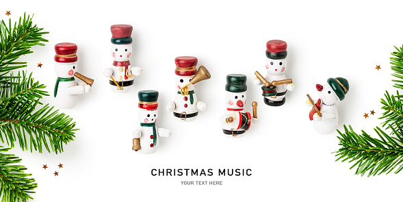 Snowmen playing music instruments, fir tree branch and stars creative layout. Christmas decoration isolated on white background. Flat lay, top view. Design element