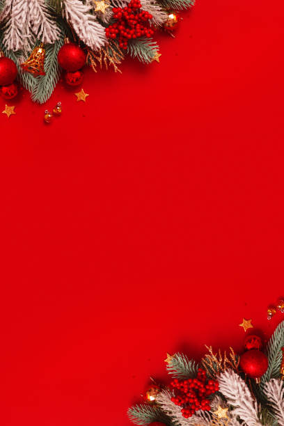 istock Christmas decoration and pine tree on red background with copy space. New Year greeting card. Vertical format 1438150951