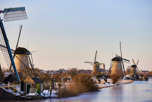 Several windmills in winter at the Kinderdijk, Holland. The water is frozen and all the land is covered with snow.