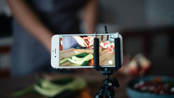 istock Vlogger man shoots video for his followers in the kitchen ,Device screen 1438151689