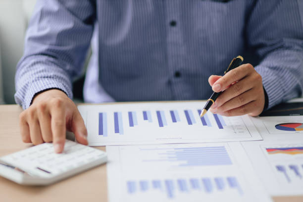 istock Businessman using a calculator to calculate numbers on a company's financial documents, analyzing historical financial data to investment planning in the future. Finance and Accounting Concepts 1438154417