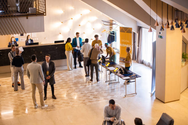 business conference participants socializing in the lobby of a hotel before the conference begins - event convention center business hotel imagens e fotografias de stock