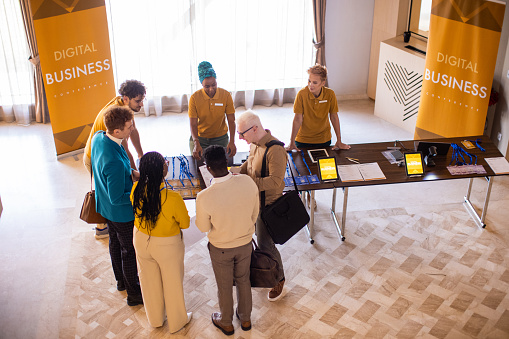 A group of business conference participants registering for a conference in the lobby of a luxury hotel