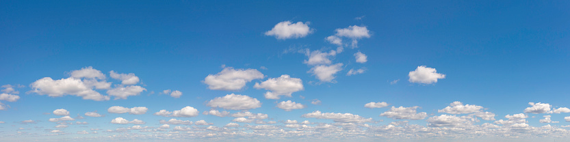 Panoramic skyscape from the horizon of clouds in a blue sky in summer.