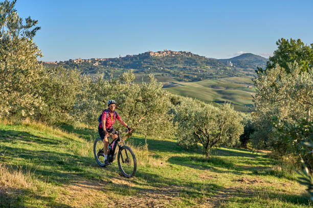 ältere frau mit ihrem elektro-mountainbike in chianti, toskana, italien - chianti region stock-fotos und bilder