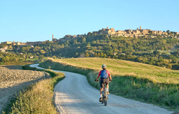 senior woman riding her electric mountain bike in Chianti, Tuscany, Italy stock photo