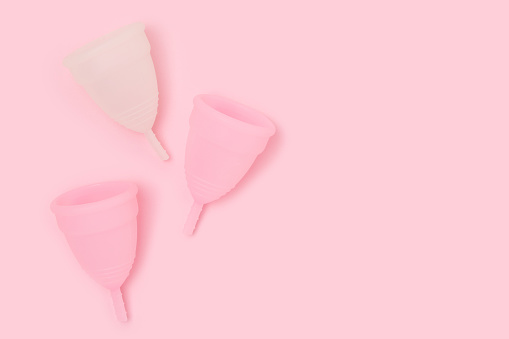 Copas menstruales sobre fondo rosa pastel. photo