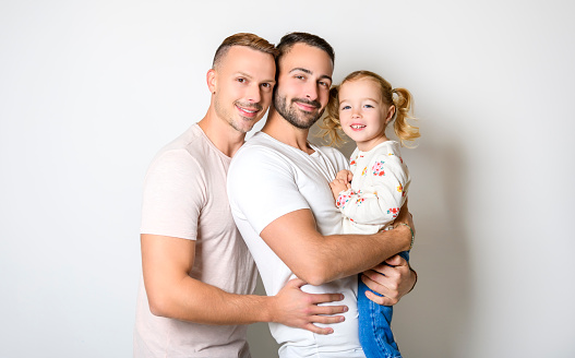 A Two man couple with adopted child girl on white background