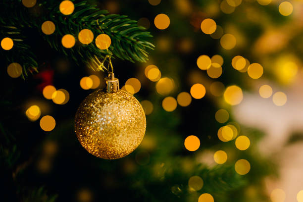 istock Golden decoration on Christmas tree. Holiday background with bokeh lights 1438159657