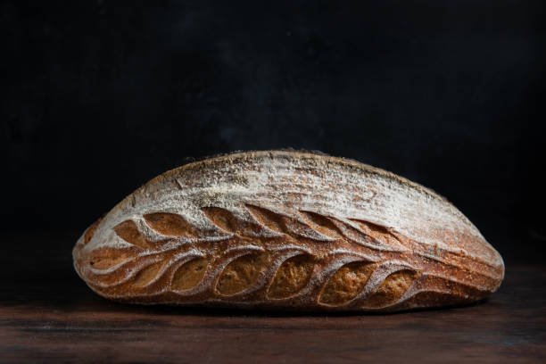 Sourdough bread beautifully decorated on rustic table. Side view