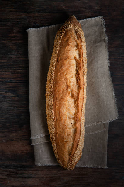 istock Fresh French baguettes on table  with linen tablecloth. Top view. 1438159791