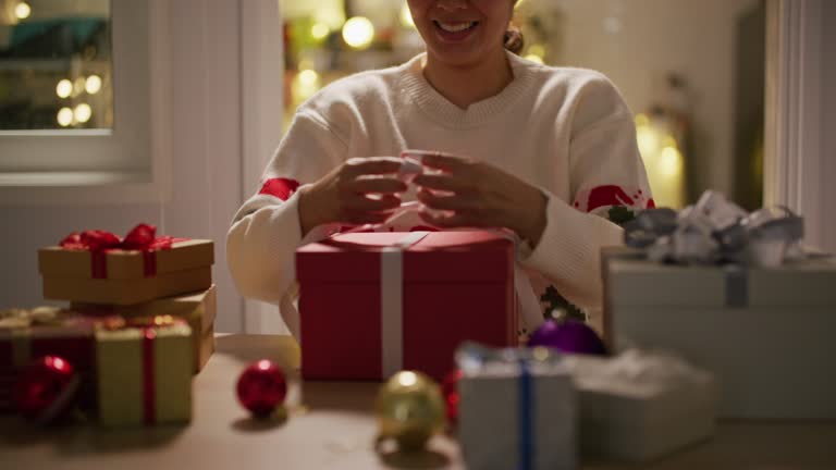 Gift wrapping. woman tie a White ribbon bow