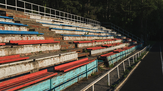 Very old dilapidated stadium stands of the city stadium. Summer sunny day