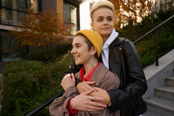 istock Blonde hugs her girlfriend in yellow hat from the back 1438161666