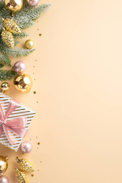 新年の飾りのコンセプト。分離型パステルベージュ背景に現在の箱の金とピンクのつまらない松ぼりの松ぼっくりの装飾品のモミの枝とコピー用スペースを持つ上面図 - pine tree pine cone branch isolated ストックフォトと画像
