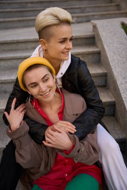 istock Smiling young women sit embracing on the steps 1438161710