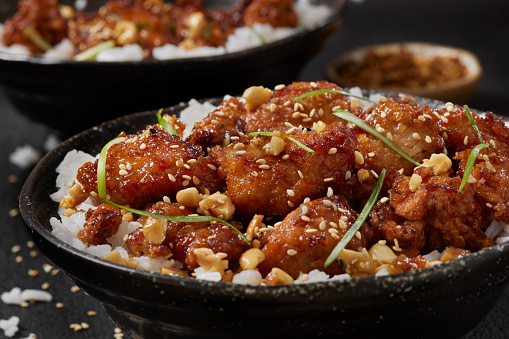 Stir fry with chicken, red paprika, mushrooms and chives in frying pan. Asian cuisine dish. Gray kitchen table background, top view, copy space