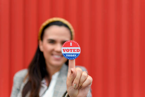 istock Young woman holding voting badge, sticker. 1438168231
