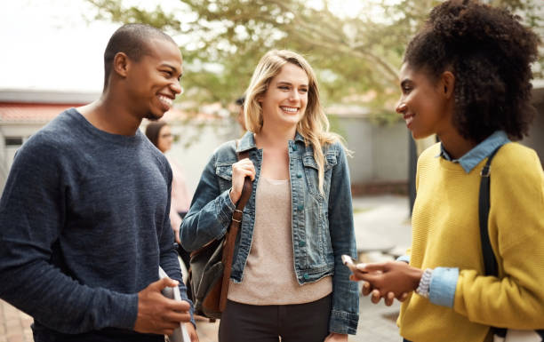 istock Happy, speaking and university friends at campus discussing a school project while on a break. Happiness, diversity ad students talking about work together outside of their academy or college. 1438168980