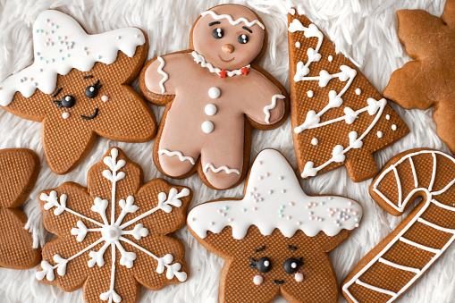 Top view fo many homamede brown gingerbread cookies decorated with icing. Christmas and new year sweets.