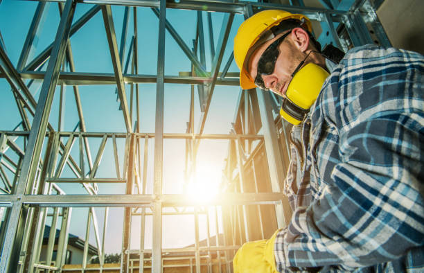 istock Tired Construction Worker in Front of Steel House Frame 1438169219