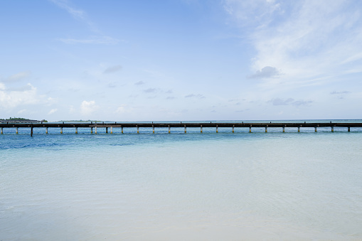 Wooden bridge over the water leading to water villas
