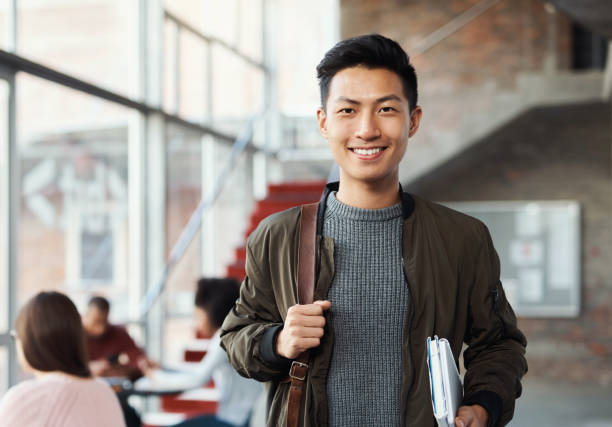 College, university and campus student with backpack, books and smile inside building for education, knowledge and learning. Portrait of asian man happy for scholarship to study and learn for future estudiante universitario, universitario y del campus con mochila, libros y sonrisa dentro del edificio para la educación, el conocimiento y el aprendizaje. retrato de hombre asiático feliz por la beca para estudiar y aprender para el futuro