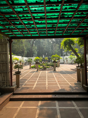 Stock photo showing a back yard that has been converted into a Japanese garden, with many oriental elements laid out around a paved courtyard. Located at Lodhi Gardens, New Delhi with free entry for all to view this collection.
