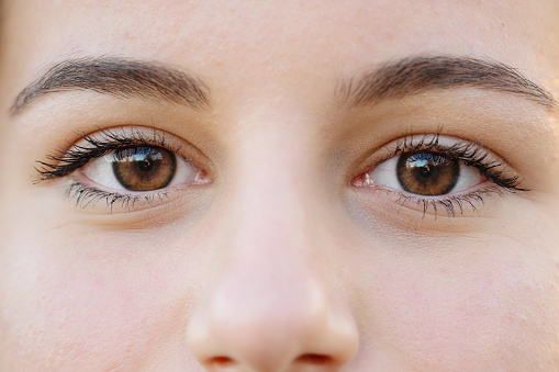 Closeup macro shot of blue human female eyes. Woman with natural vogue face beauty makeup.