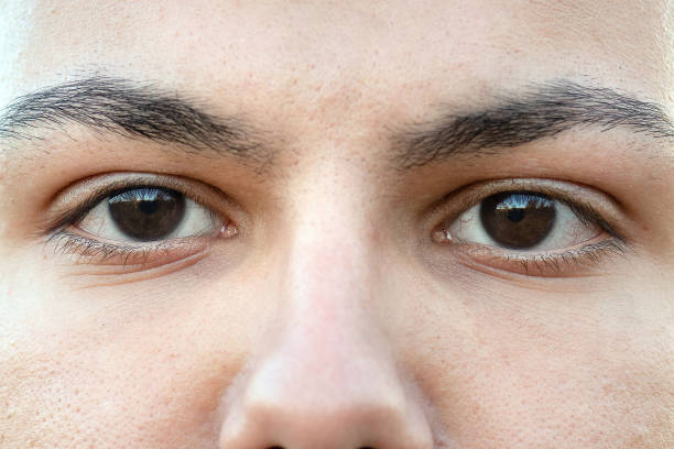 istock Close up of young man's brown eyes looking at camera 1438172470