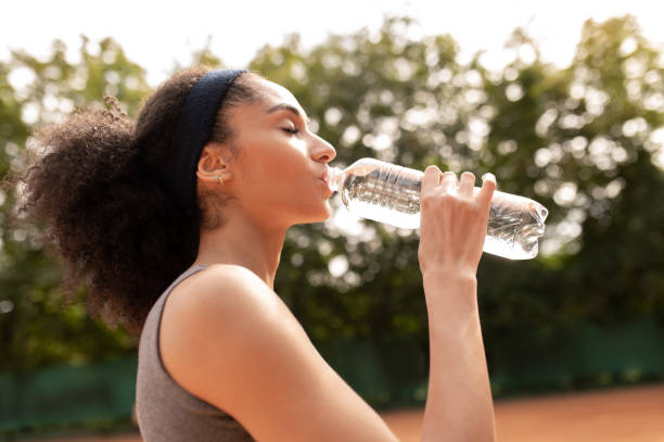 istock Pretty young girl drinking water after exercising 1438173865