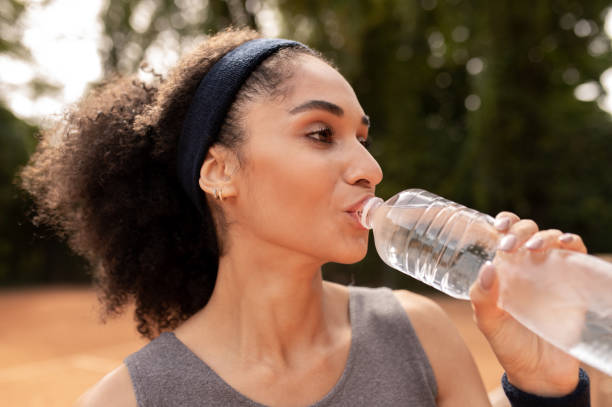 istock Pretty young girl drinking water after exercising 1438173950
