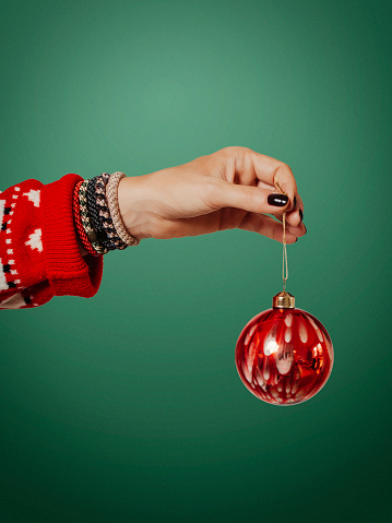 Woman holding christmas decoration ornate bauble side view
Studio light