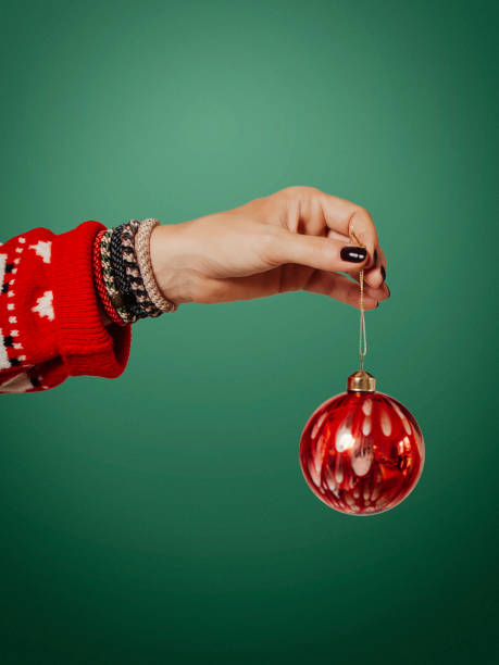 Woman holding christmas decoration ornate bauble side view stock photo