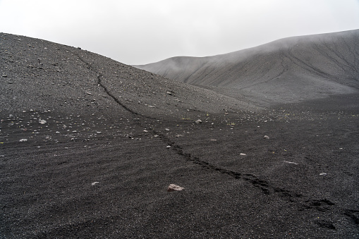 Huge Hverfjall volcanic crater on cloudy day.  Hverfjall, is one of the best preserved circular volcanic craters in the world and it is possible to walk around and inside it.