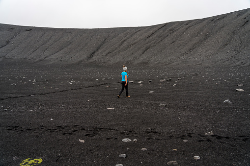 One women at the bottom of the Hverfjall volcanic crater.  Hverfjall, is one of the best preserved circular volcanic craters in the world and it is possible to walk around and inside it.