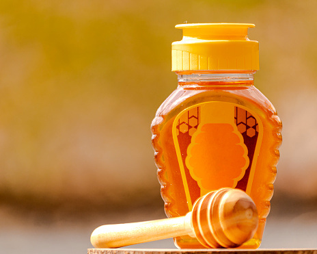 honey in a plastic bottle with a blur background