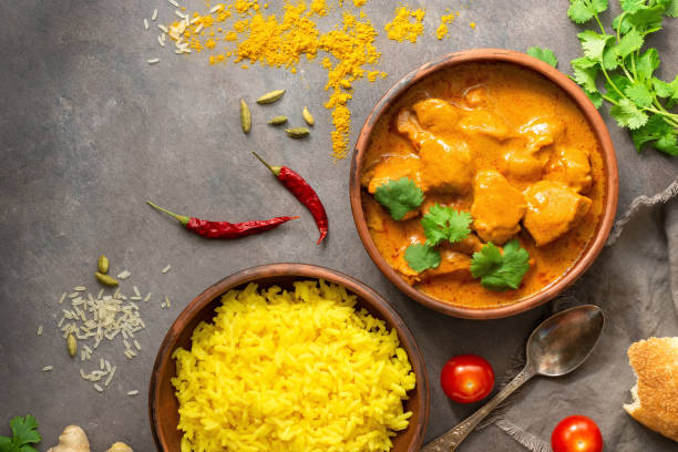 Chicken tikka masala spicy curry meat food in bowl, rice and naan bread, dark background. View from above. Traditional Asian food. Chicken tikka masala spicy curry meat food in bowl, rice and naan bread, dark background. View from above. Traditional Asian food. Butter Chicken stock pictures, royalty-free photos & images