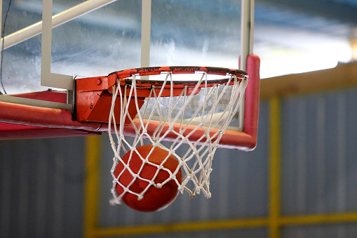 Focus scene on basketball ball during indoor competition.