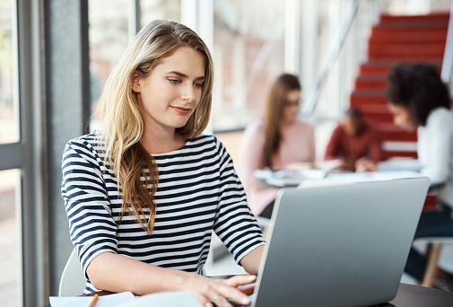 Laptop, studying and student woman with project research, online course or website for university, scholarship or school information. College girl typing on her pc at the students workspace or campus