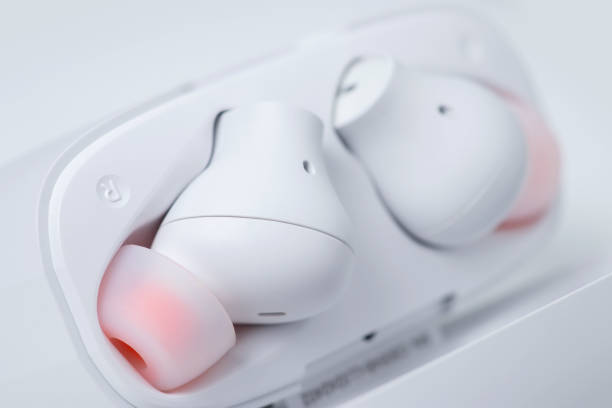 istock Two white wireless headphones in a case on a white background 1438176303
