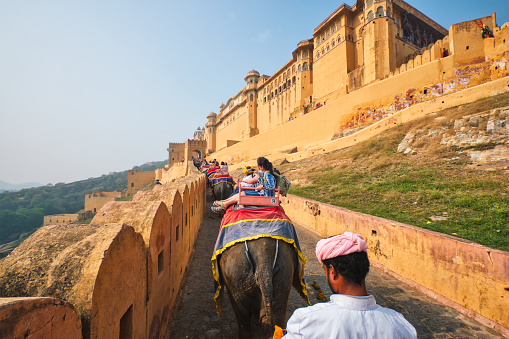 Amer, India - November 2, 2019: First person FPV point of view POV of tourists riding elephants on ascend to Amer (Amber) fort, Rajasthan, India. Amer fort is famous tourist destination and landmark