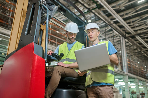 istock Men in protective helmets working in a storage area 1438177791