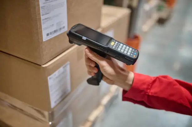 Photo of Warehouse employee scanning packaging information using a scanner