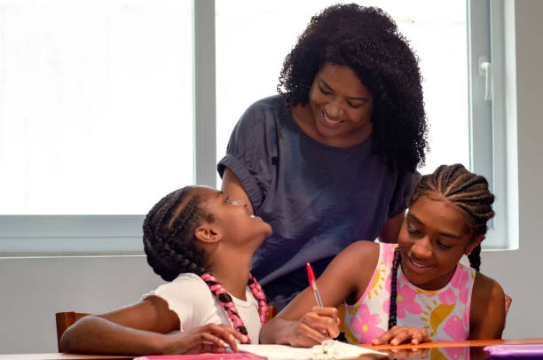 istock Mother helping her daughters with homework 1438179054