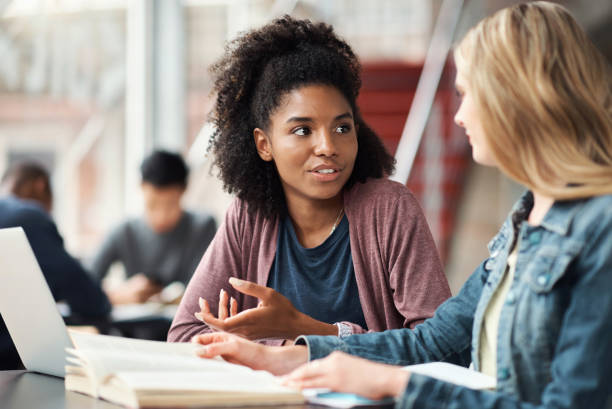 diversidade, educação de mulheres ou estudantes com laptop, notebook ou aprendizagem em colagem, escola ou biblioteca universitária. trabalho em equipe, colaboração ou amigos para bolsa de estudos, relatório de redação ou pesquisa tecnológica - report reading business book - fotografias e filmes do acervo