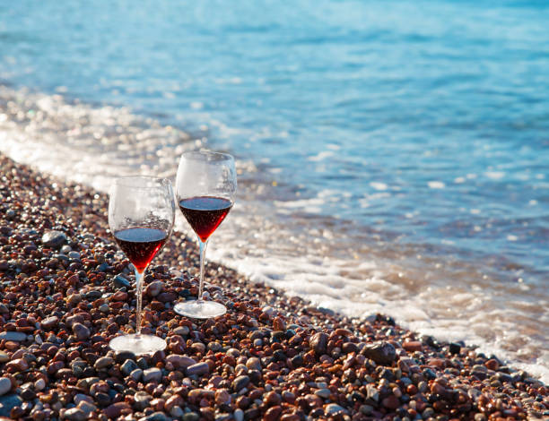 istock glasses with red wine on the beach 1438181166