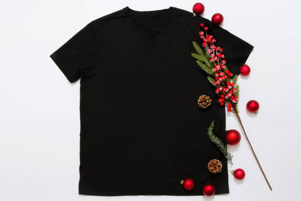 Close up black blank template t shirt with copy space and Christmas Holiday concept. Top view mockup t-shirt and red holidays decorations on white background. Happy New Year accessories. Xmas outfit cerrar la camiseta negra de la plantilla en blanco con espacio de copia y concepto de vacaciones de navidad. camiseta de maqueta de vista superior y decoraciones navideñas rojas sobre fondo blanco. accesorios de feliz año nuevo. traje de navidad