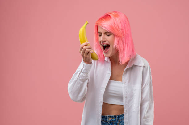 istock Modern young woman performing a song with a fruit mike 1438182064